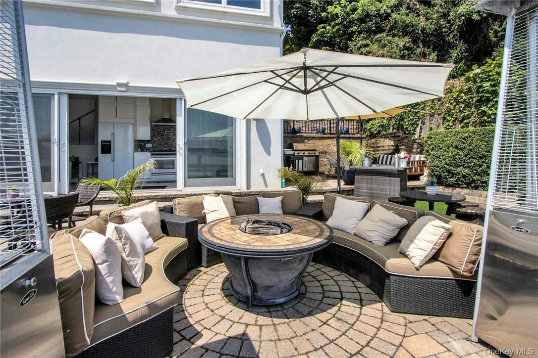 74 River Road Nyack, NY 10960 - Photo 32 of 36 a view of a patio with a dining table and chairs under an umbrella