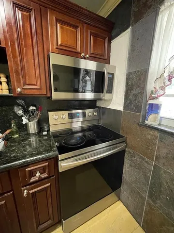 a kitchen with granite countertop a refrigerator oven a sink and dishwasher
