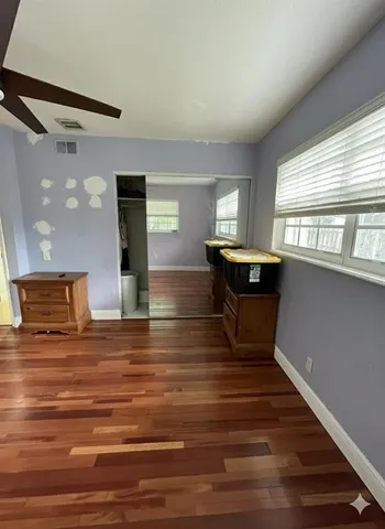 a view of a room with wooden floor and window