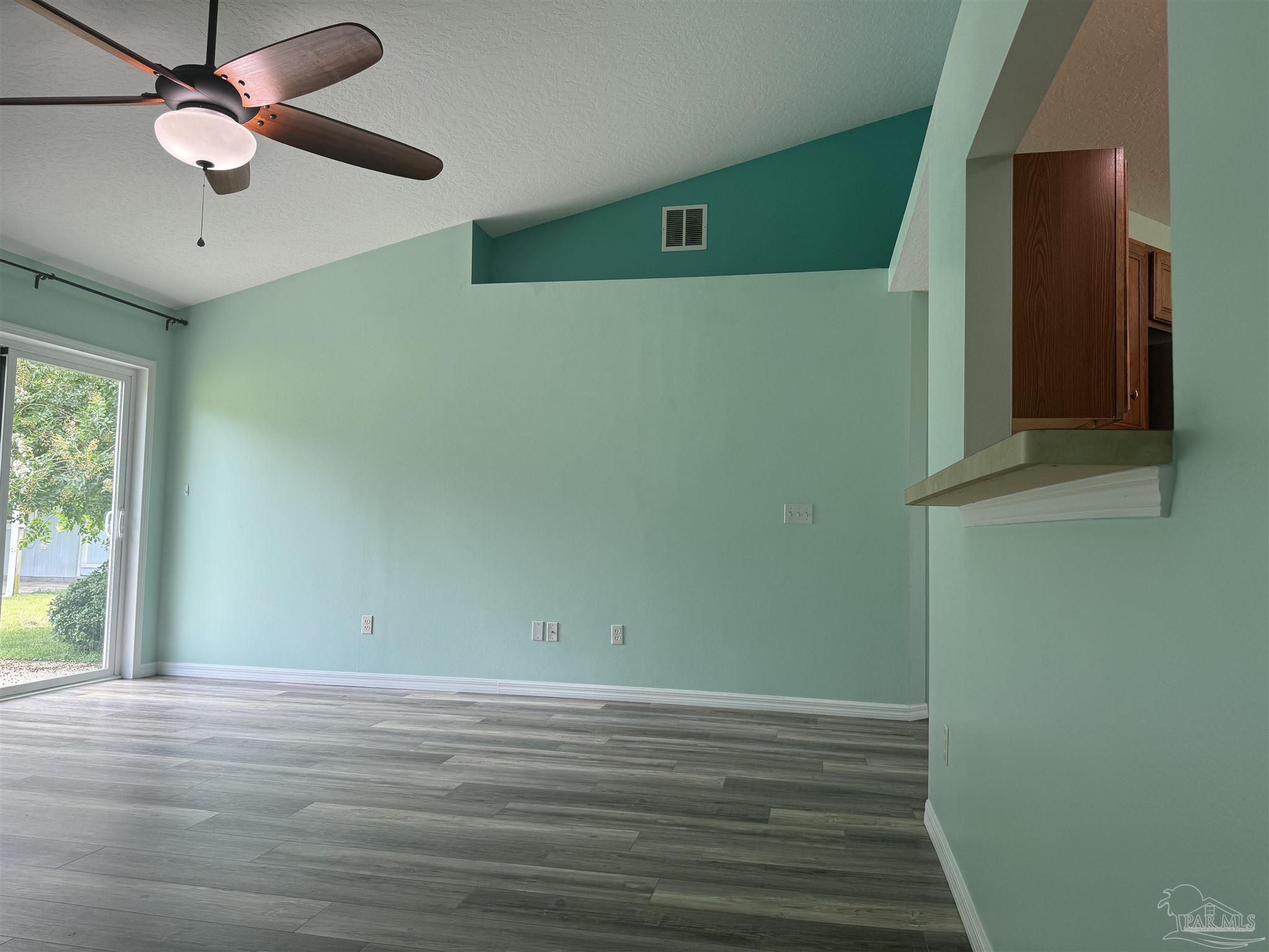 8281 Segura Street Navarre, FL 32566 - Photo 11 of 24 an empty room with wooden floor and windows