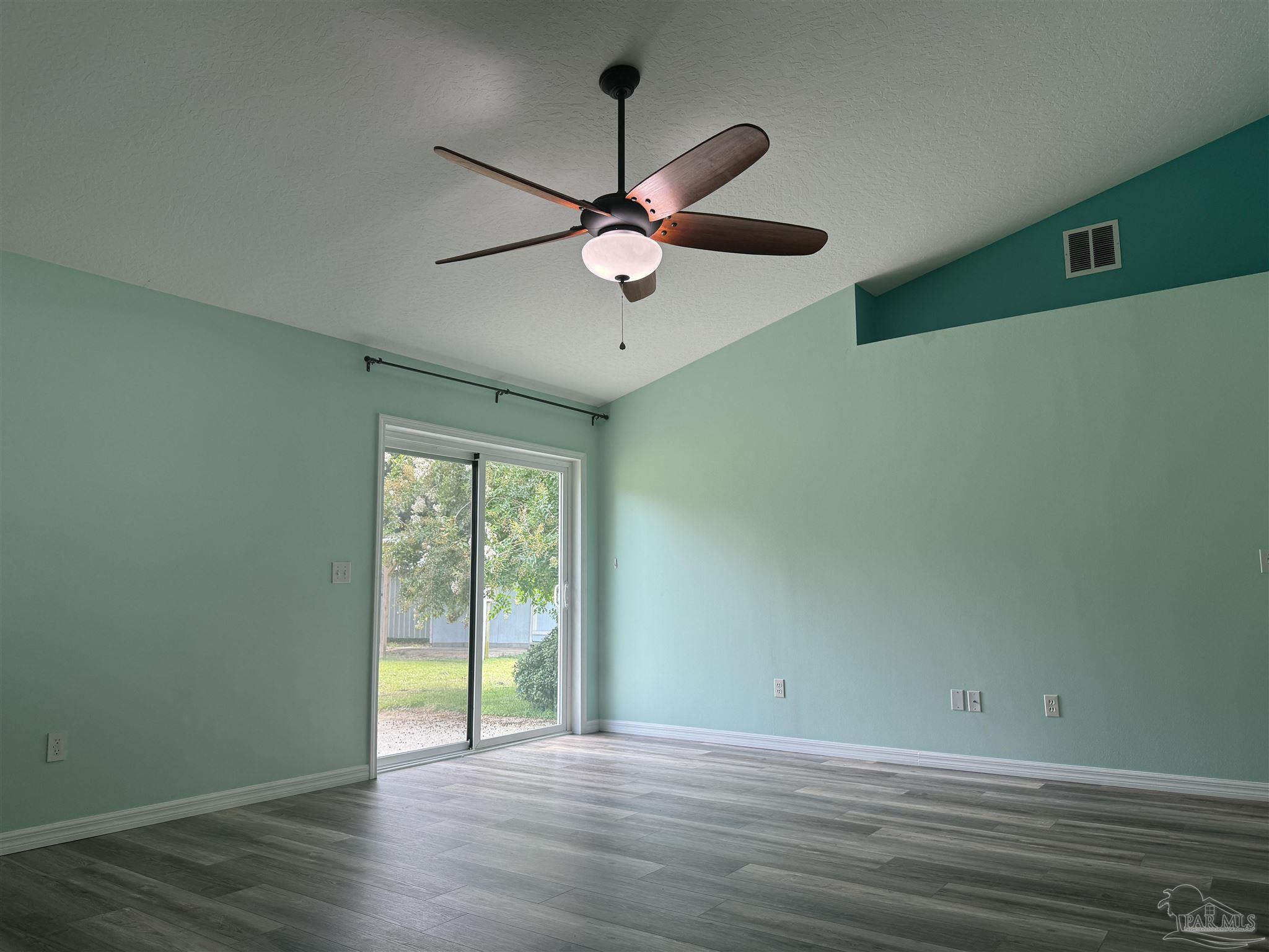 8281 Segura Street Navarre, FL 32566 - Photo 12 of 24 a view of an empty room with window and wooden floor