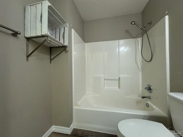 a bathroom with a toilet and a bath tub