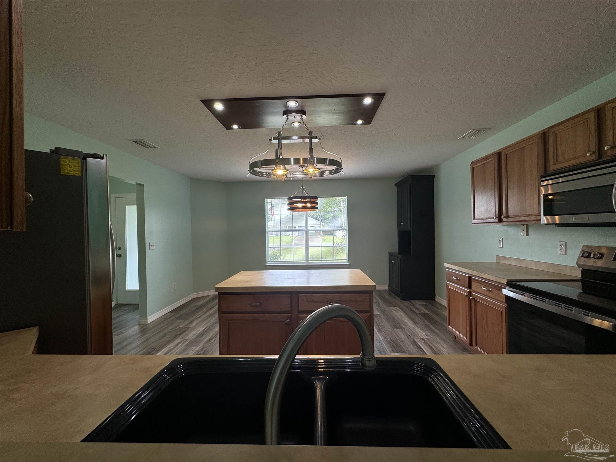8281 Segura Street Navarre, FL 32566 - Photo 6 of 24 a kitchen with a sink stove and refrigerator