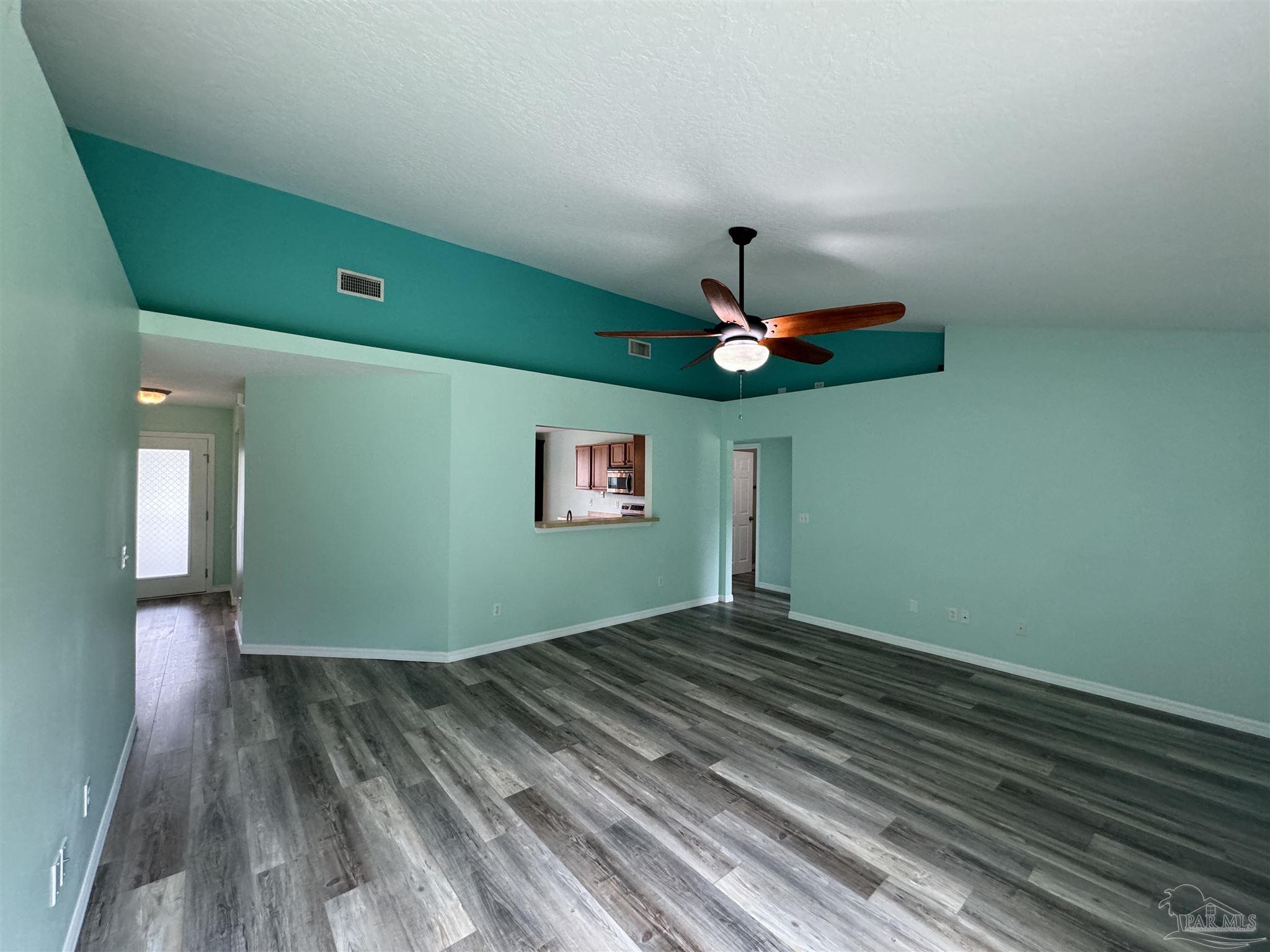 8281 Segura Street Navarre, FL 32566 - Photo 9 of 24 a view of a room with a ceiling fan and wooden floor