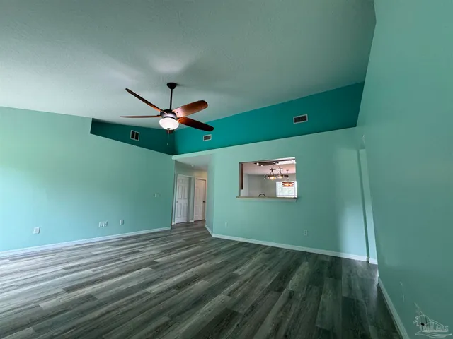 a view of a room with a ceiling fan and hardwood floor