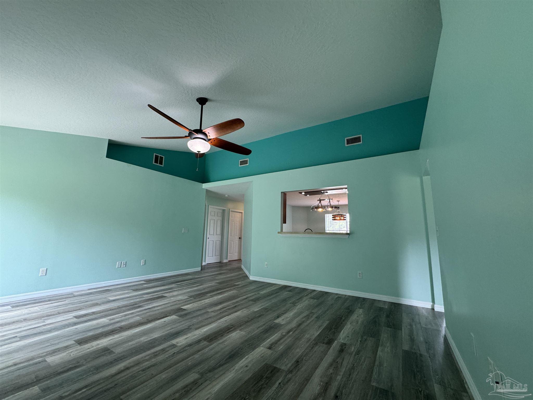 8281 Segura Street Navarre, FL 32566 - Photo 10 of 24 a view of a room with a ceiling fan and hardwood floor