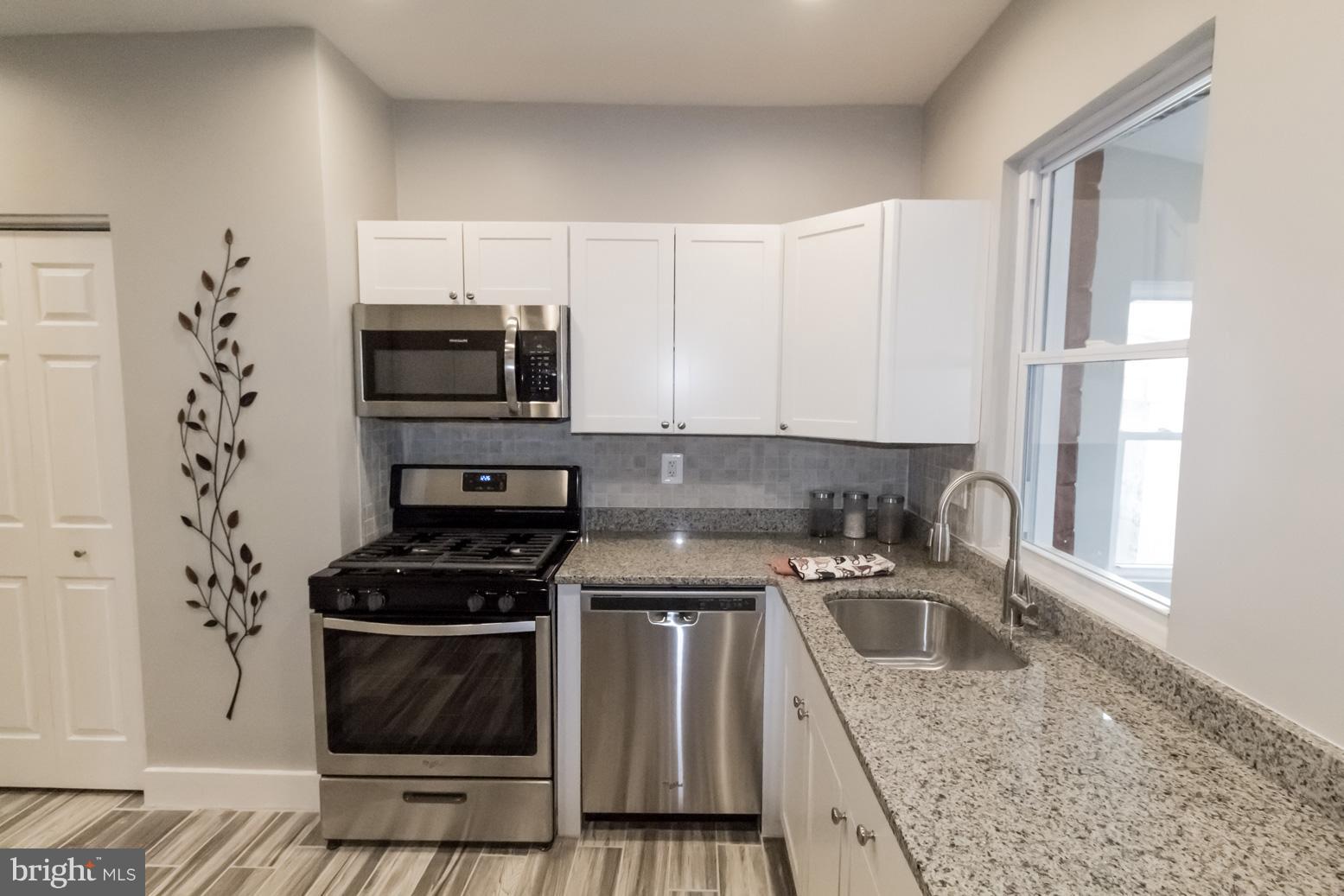 1743 Portship Road Baltimore, MD 21222 - Photo 14 of 30 a kitchen with stainless steel appliances granite countertop a stove a sink and a microwave