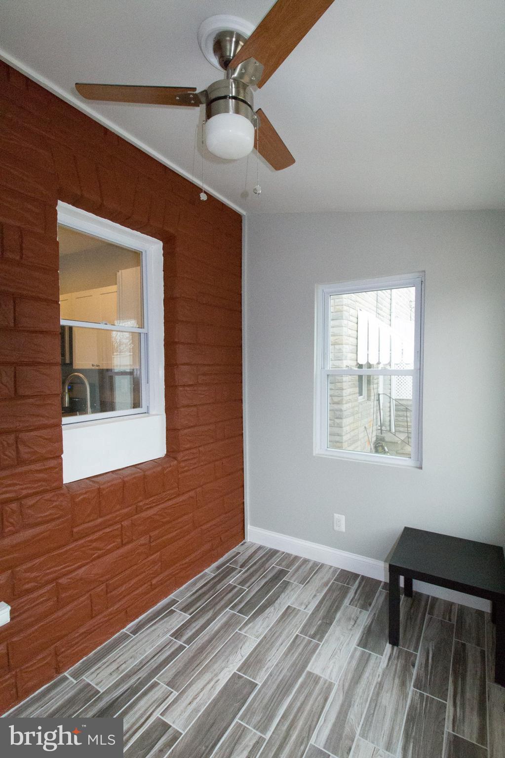 1743 Portship Road Baltimore, MD 21222 - Photo 18 of 30 a view of an empty room with a window and wooden floor