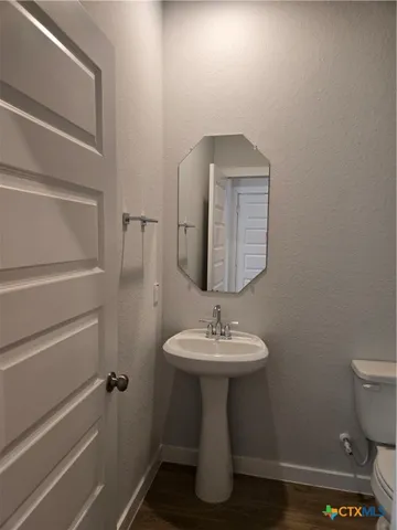 a bathroom with a sink toilet and mirror