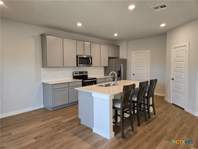 a kitchen with a sink a microwave and cabinets