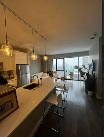 a kitchen with a table chairs stove and wooden floor