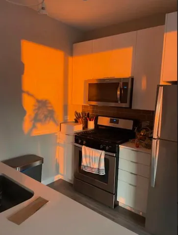 a kitchen with stainless steel appliances a stove a microwave and a sink