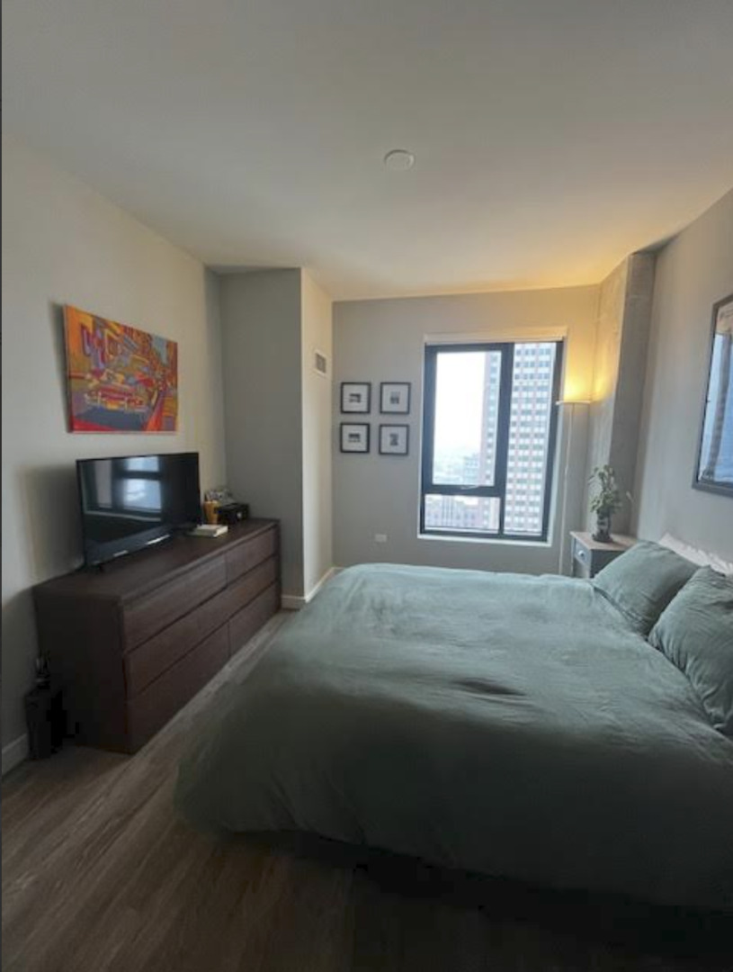833 North Clark Street, Unit 2408 Chicago, IL 60610 - Photo 9 of 21 a bedroom with a bed and a flat screen tv