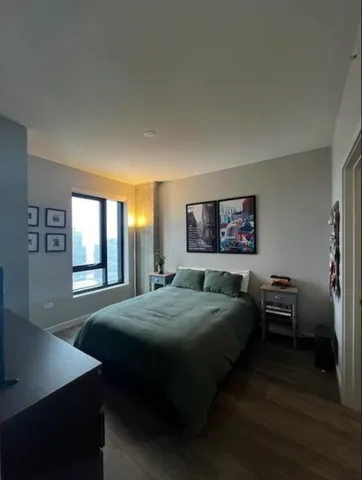 a bedroom with a bed and a table in it with window