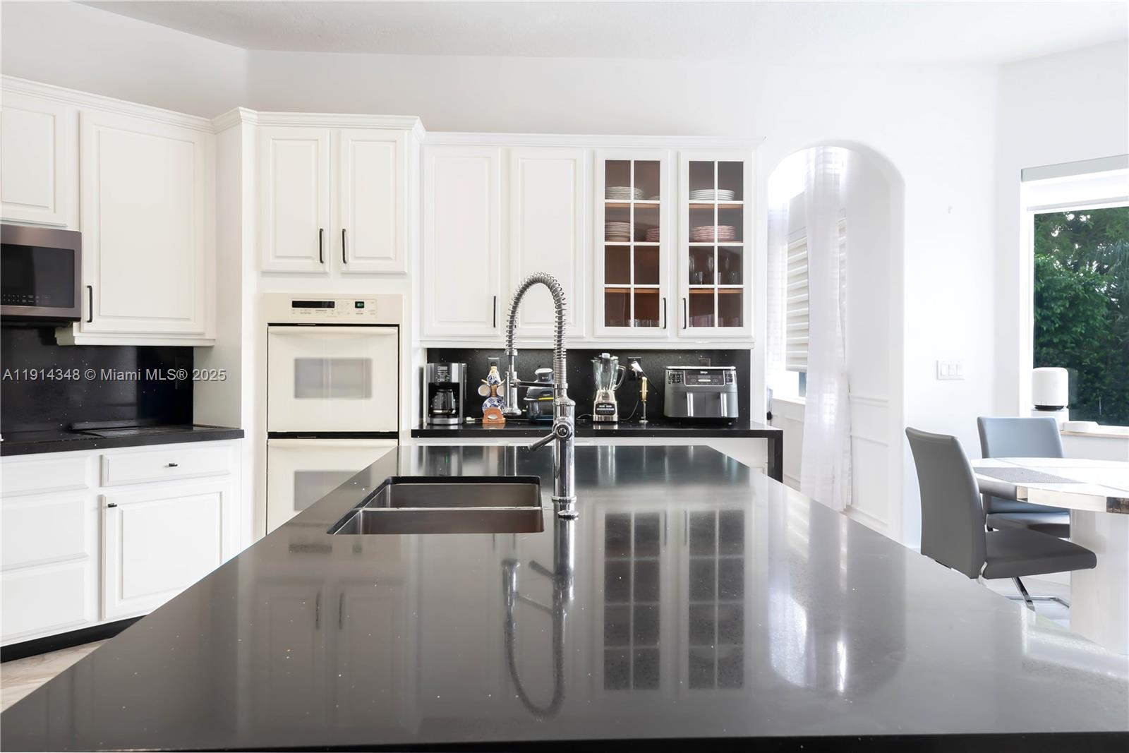 19250 Southwest 30th Street, Unit 50 Miramar, FL 33029 - Photo 23 of 61 a kitchen with stainless steel appliances kitchen island granite countertop a refrigerator a stove a sink and white cabinets with wooden floor
