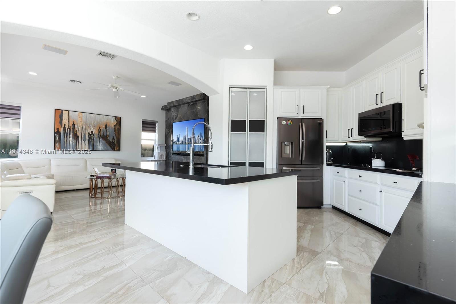 19250 Southwest 30th Street, Unit 50 Miramar, FL 33029 - Photo 34 of 61 a large white kitchen with stainless steel appliances kitchen island granite countertop a refrigerator and a stove top oven