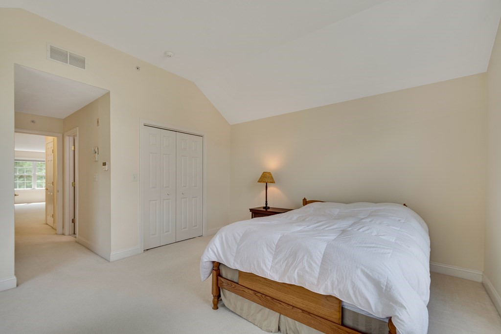 508 Linwood Court, Unit 508 Clinton, MA 01510 - Photo 22 of 28 a bed sitting in a spacious bedroom next to a bathroom