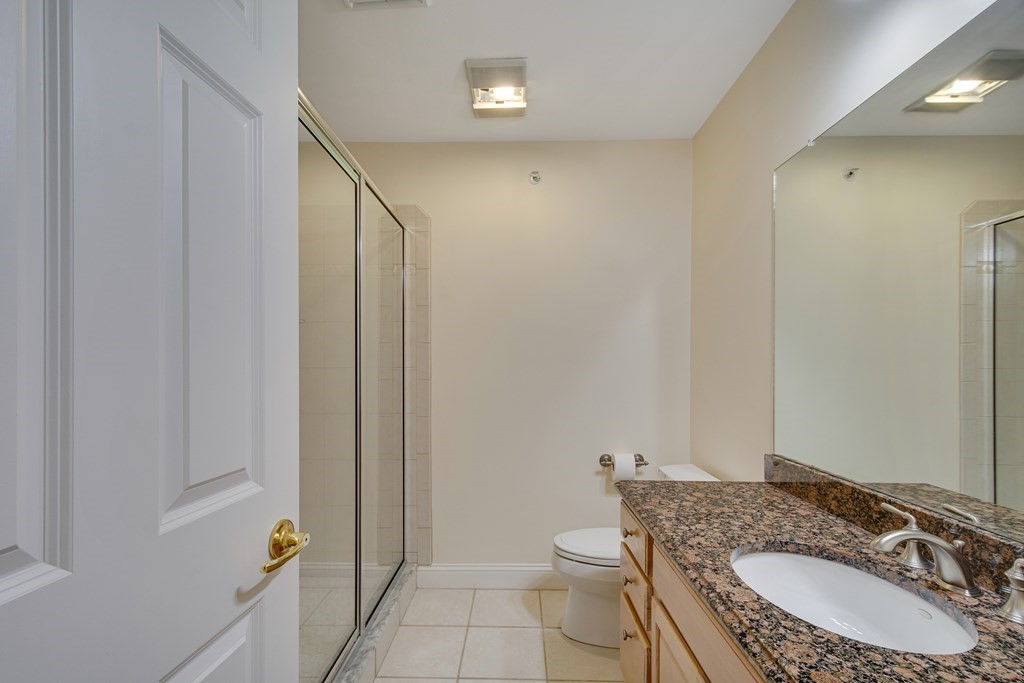508 Linwood Court, Unit 508 Clinton, MA 01510 - Photo 23 of 28 a bathroom with a granite countertop sink a toilet and a mirror