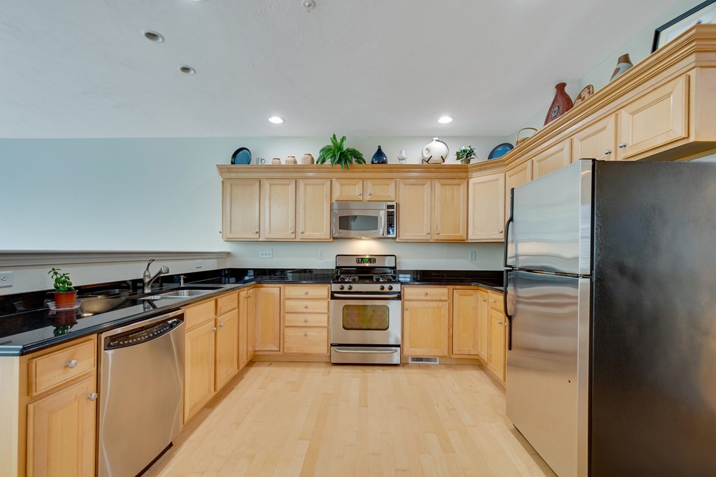 508 Linwood Court, Unit 508 Clinton, MA 01510 - Photo 8 of 28 a kitchen with stainless steel appliances granite countertop a stove a sink and a refrigerator
