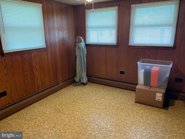 a view of an empty room with windows & cabinet