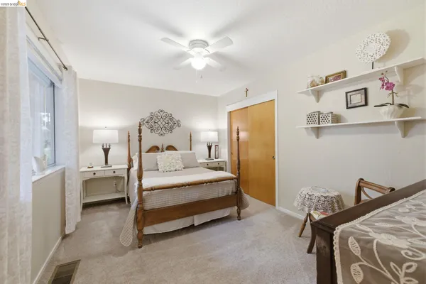a spacious bedroom with a bed and a chandelier
