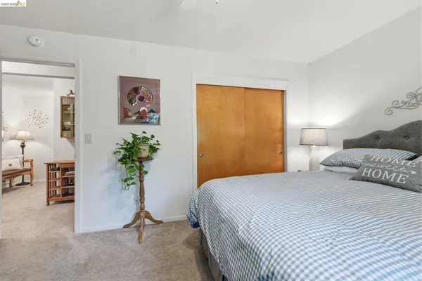 a bedroom with a bed and a painting on the wall