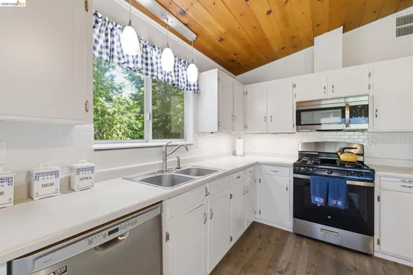a kitchen with stainless steel appliances a sink a stove and cabinets
