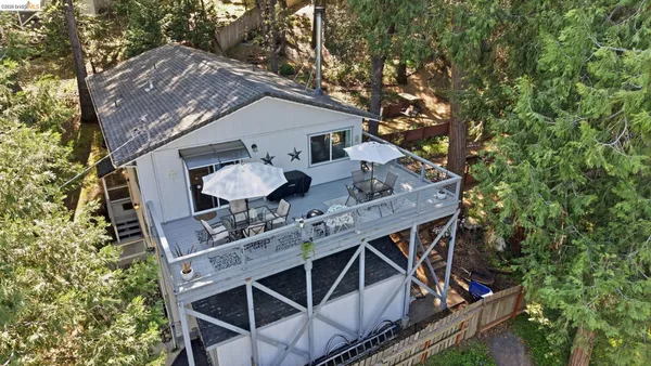 a roof deck with table and chairs under an umbrella