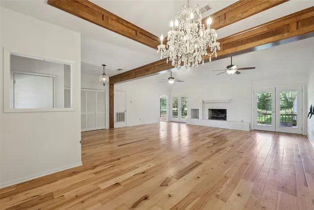 a view of a livingroom with a fireplace wooden floor and chandelier