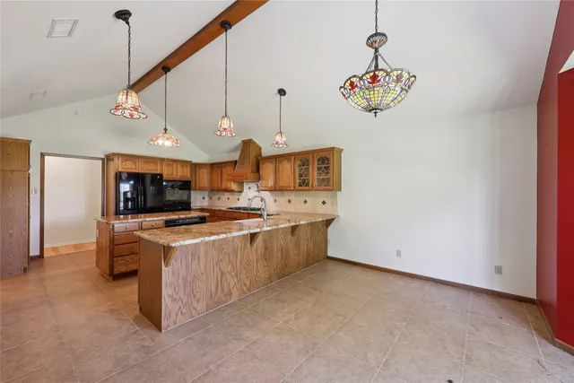a large kitchen with stainless steel appliances granite countertop a stove and a sink
