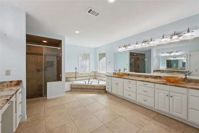 a large bathroom with a large mirror vanity and a shower