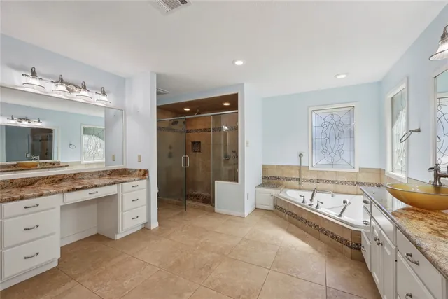 a spacious bathroom with a granite countertop tub sink and mirror