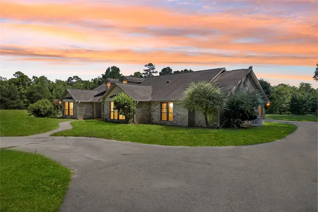 a view of a big house with a big yard and large trees