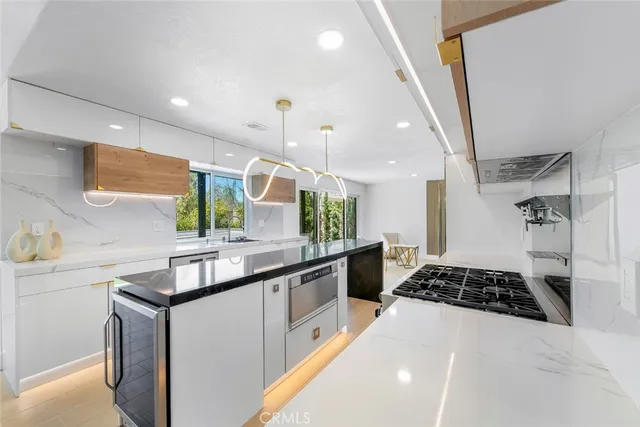 a kitchen with stainless steel appliances a sink stove and cabinets