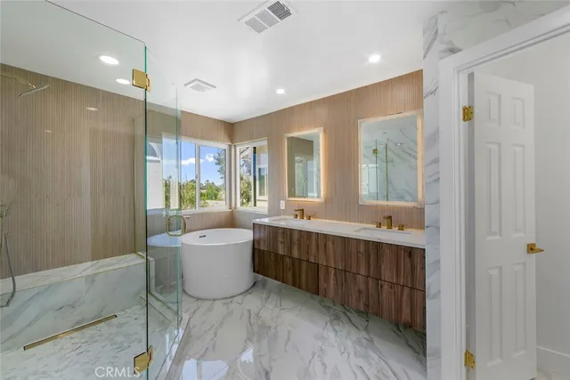 a bathroom with a double vanity sink a mirror and a bathtub
