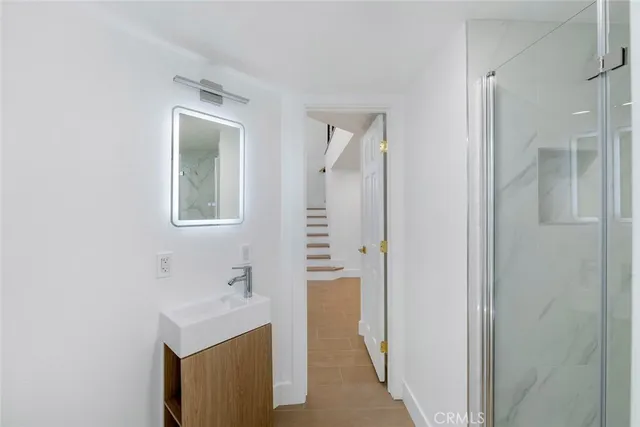 a en suite bathroom with a sink a mirror and a shower