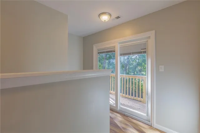 a view of a hallway with wooden floor and a window