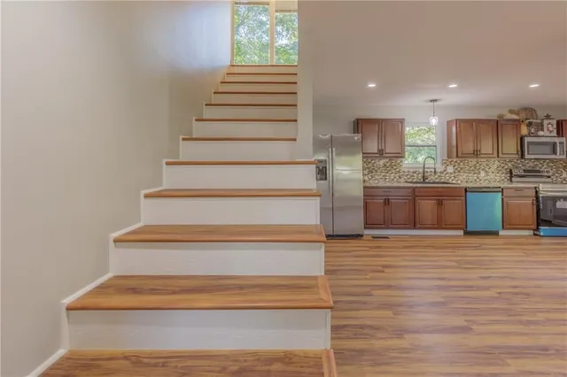 a large kitchen with stainless steel appliances granite countertop a large counter top a sink and a refrigerator