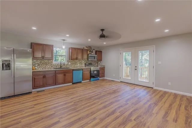 a large kitchen with kitchen island a sink stainless steel appliances and cabinets