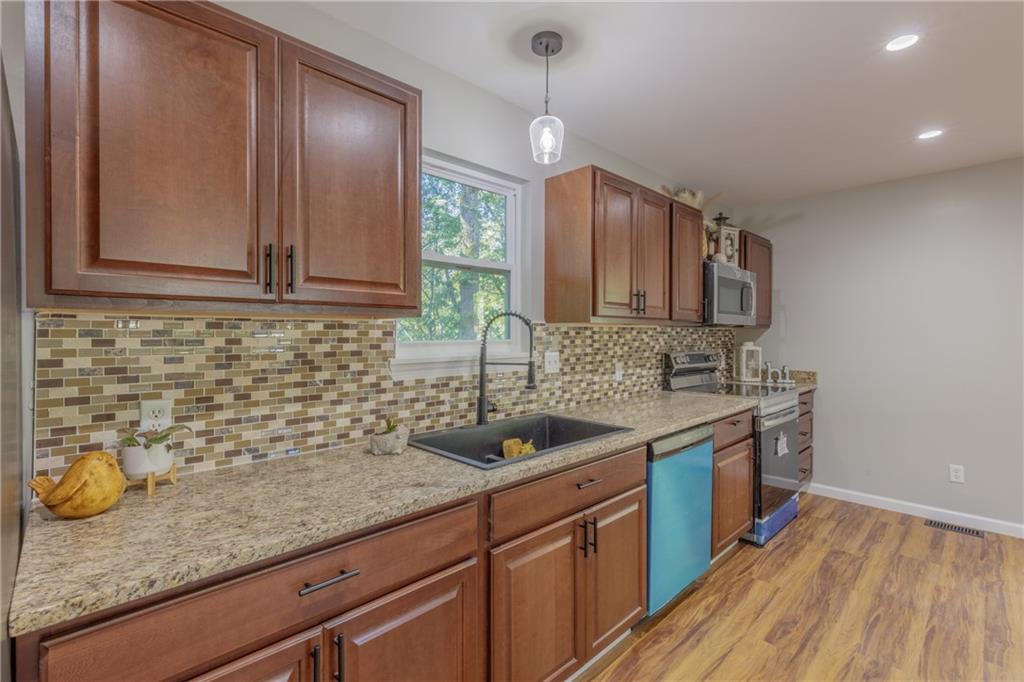 55 Reece Street Menlo, GA 30731 - Photo 9 of 46 a kitchen with stainless steel appliances granite countertop a sink a stove and a wooden cabinets