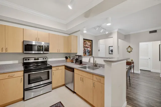 a kitchen with a sink white cabinets and stainless steel appliances
