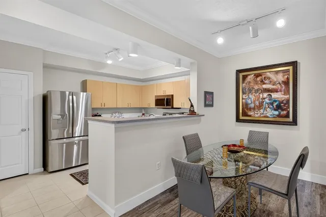 a kitchen with stainless steel appliances granite countertop a stove top oven a sink dishwasher and white cabinets with wooden floor