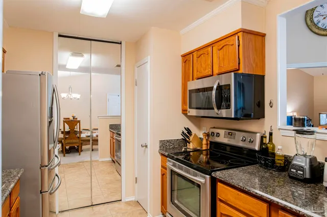 a kitchen with stainless steel appliances granite countertop a refrigerator and a stove top oven
