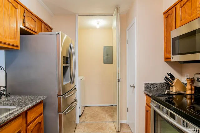 a kitchen with stainless steel appliances granite countertop a refrigerator and a stove top oven