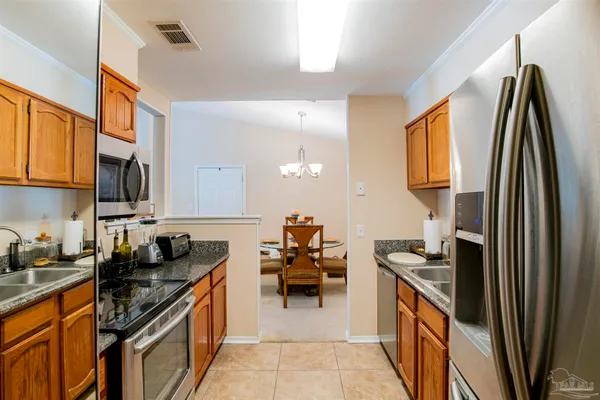 a kitchen that has a lot of cabinets a sink and appliances