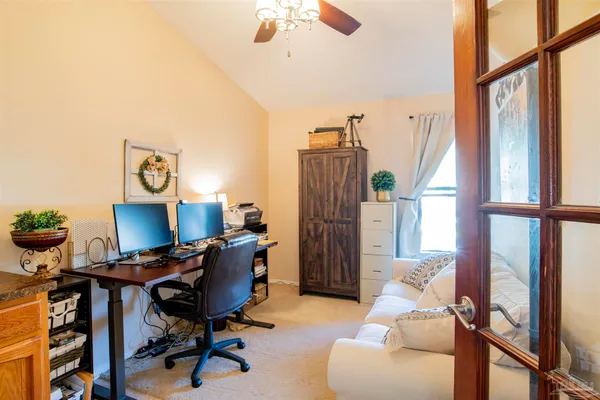 a view of a workspace with furniture and a window