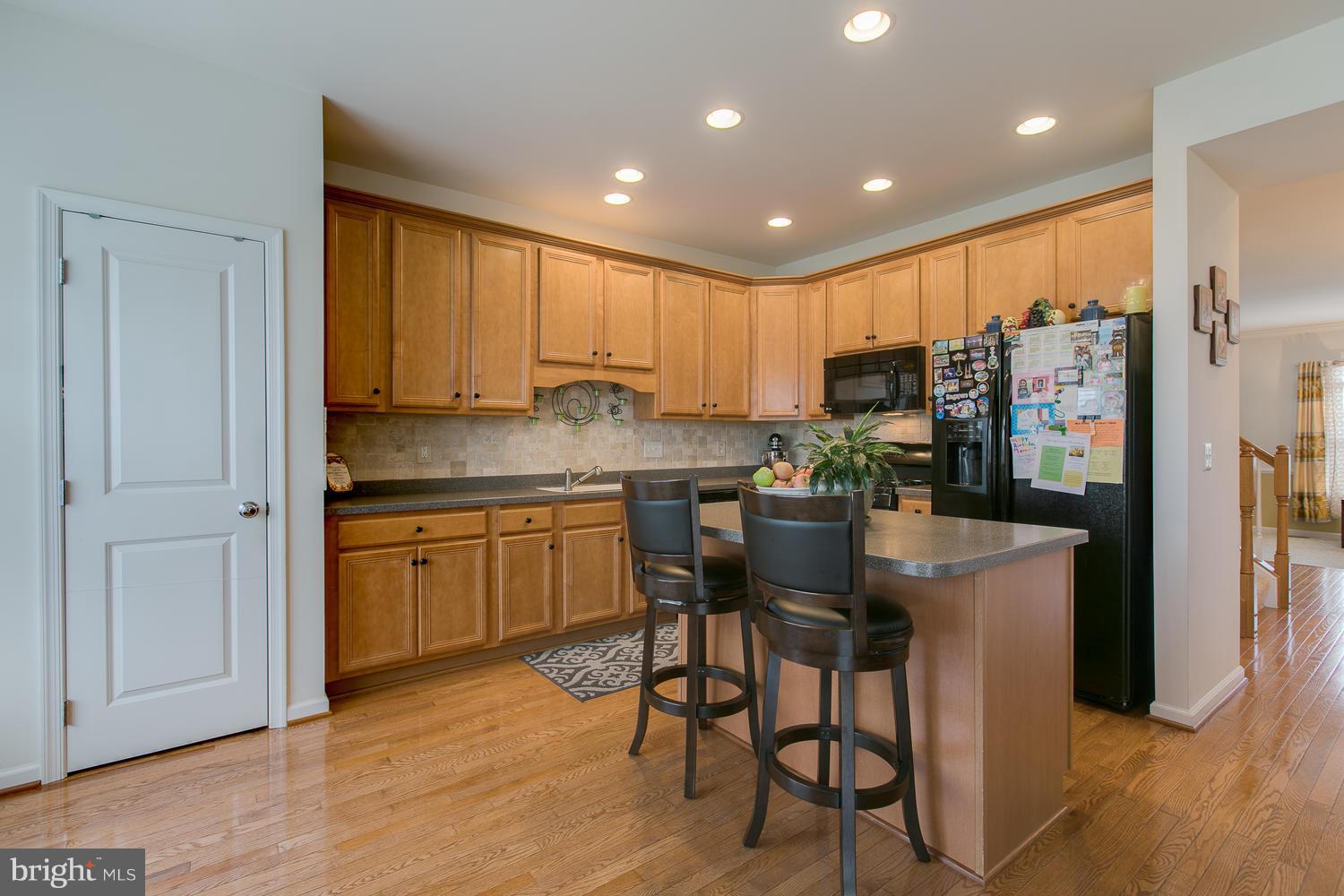 42 Short Branch Road Stafford, VA 22556 - Photo 11 of 26 a kitchen with kitchen island granite countertop wooden floors and white cabinets