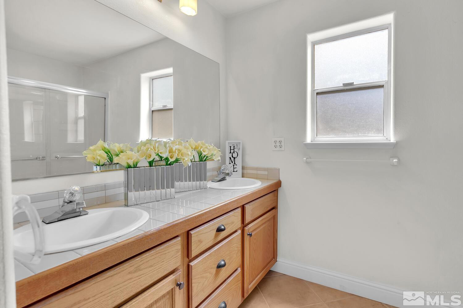 1031 University Ridge Drive Reno, NV 89512 - Photo 19 of 38 a bathroom with a granite countertop sink and a mirror
