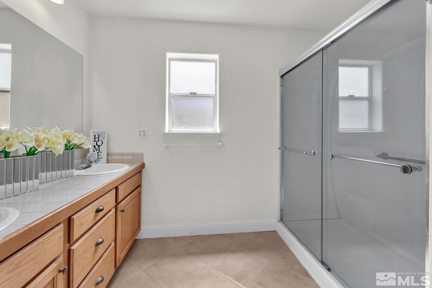 1031 University Ridge Drive Reno, NV 89512 - Photo 20 of 38 a bathroom with a shower sink and mirror