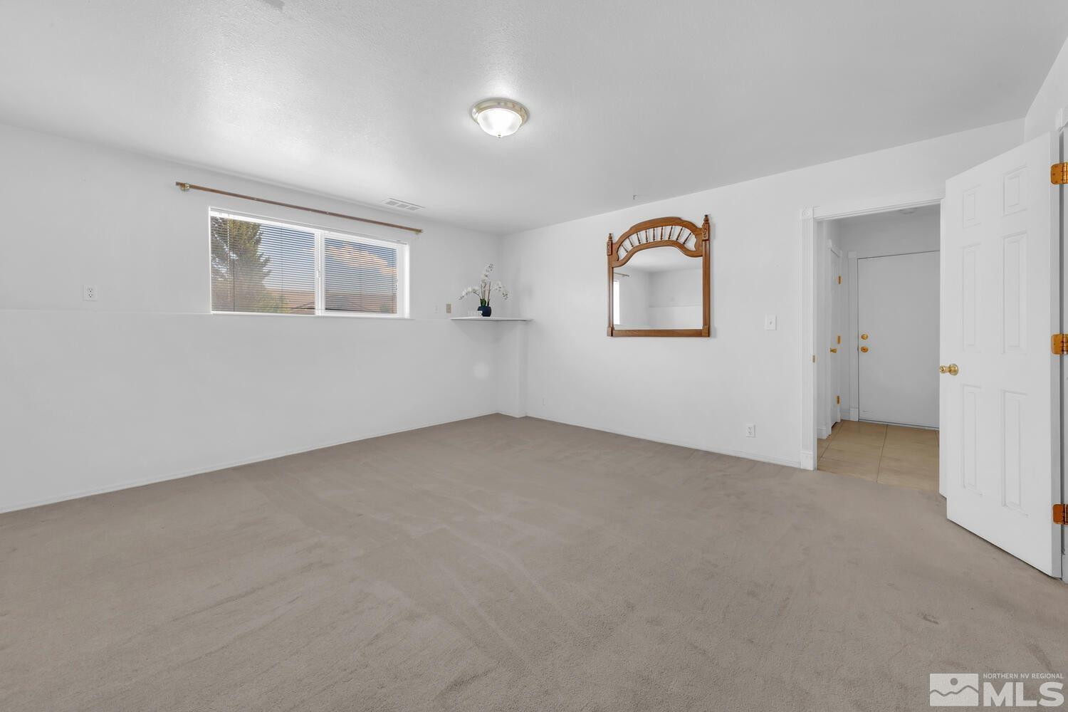 1031 University Ridge Drive Reno, NV 89512 - Photo 29 of 38 an empty room with a window and mirror